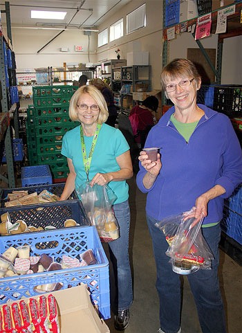 Volunteers Phyllis Anderson and Linda DeCample pack backpacks for 245 students in Renton.