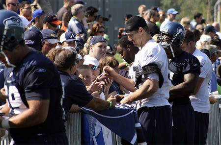 Patrick Kerney signs autographs for fans after a Seahawks training camp practice session last August.