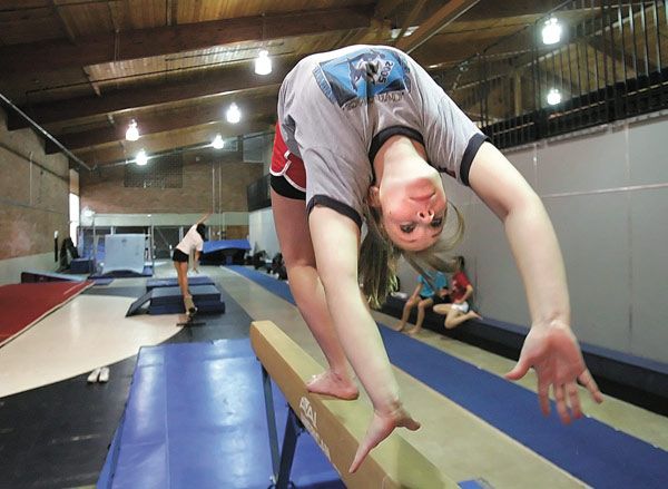 Standout Lindbergh gymnast Louise Baker performs a back walk-over on beam in practice.