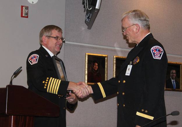 Fire Chief Mark Peterson presents a certificate of appreciation to Chaplain Allan Folmar on his retirement.