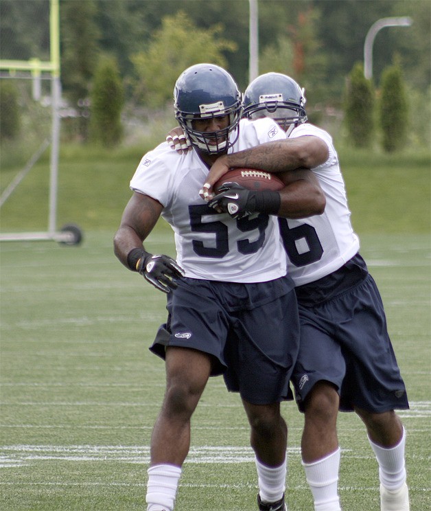 Seahawks linebacker Leroy Hill strips the ball from Aaron Curry during a drill at a June 15 practice.