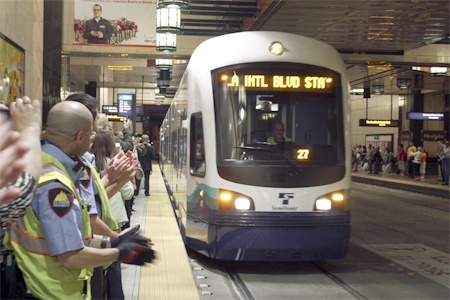 People applaud as a Sound transit light rail train pulls into Seattle’s dowtown tunnel on Friday