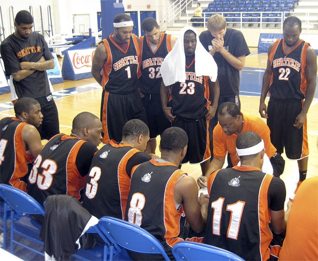 Mountaineer coach Don Sims kneels and addresses his team during a timeout.