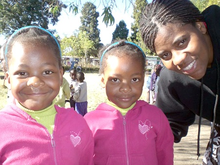 Captain Rutendo Masango of Renton with two girls at an orphanage in Zimbabwe.