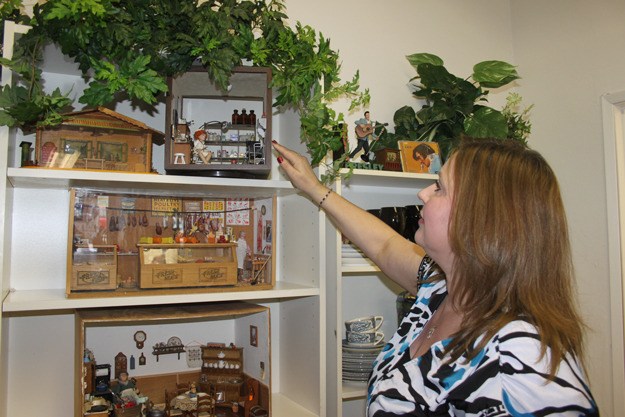 Debbie Swanson shows off a miniature doctor's office created by her mother-in-law and on display at A-1 in downtown Renton.