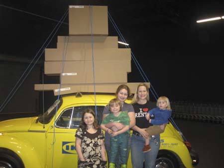 Carolyn Ossorio stands in front of the iconic IKEA Volkswagen with her kids.