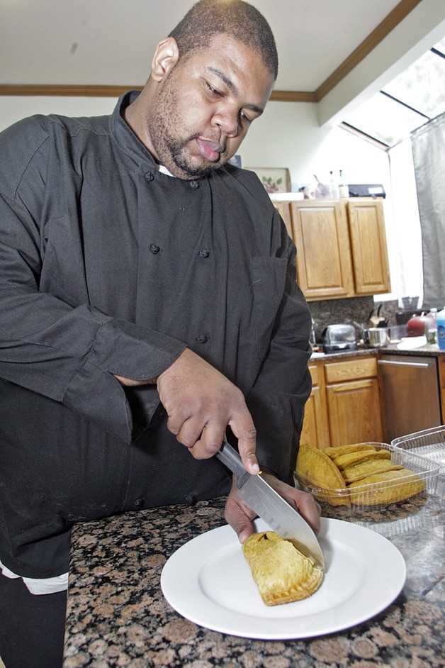 Michael Cunningham cuts into one of his freshly made Jamaican patties at home in Fairwood.