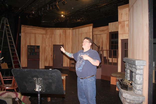 Managing Artistic Director Bill Huls works to adjust the lights on the set of 'The Foreigner
