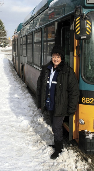 Longtime Metro bus driver Jocelle Jorgensen-Caswell stands outside her articulated bus Monday morning