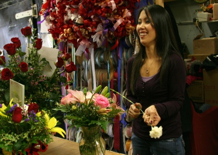 Sa Tran arranges a vase of flowers at Heritage Flowers