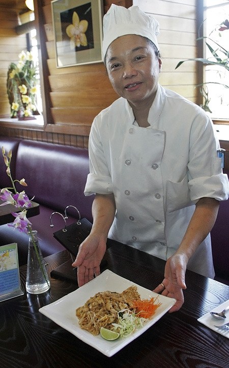 Chef Buppha Booma shows off a freshly cooked plate of pud Thai at her Royal Orchid restaurant.