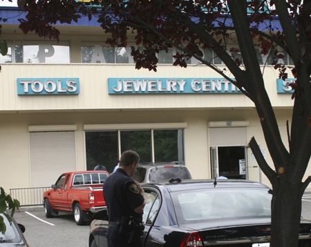 Renton Police assisted in the arrest Tuesday of a man and woman for investigation of burglary and trafficking in stolen property. The man was being held in a police car in front of the EZ Cash Pawn Shop on Sunset Boulevard
