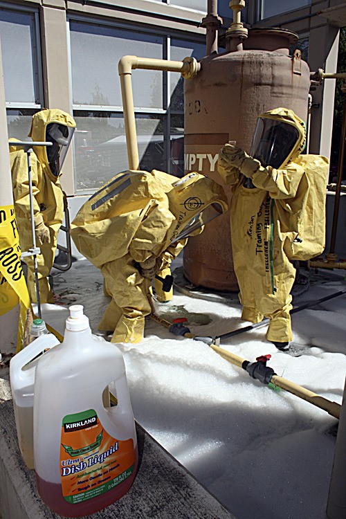 Renton firefighters take their turn Friday stopping a leak of a 'hazardous' chemical during a hazardous-materials simulation at the county's sewage-treatment plant. The soap was used to add some realism.