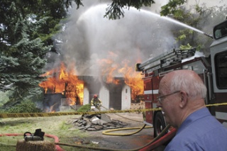 Grover Shegrud watches Thursday as the home he designed and built for his family in 1966 is burned to the ground in a live-fire practice exercise Thursday by the Renton Fire Department.