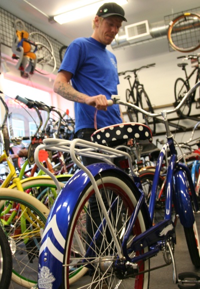 Tobias Roberts of G.H.Y. Bikes in downtown Renton looks at a beach cruiser in the shop. When Renton consumers buy locally it helps support the local community.