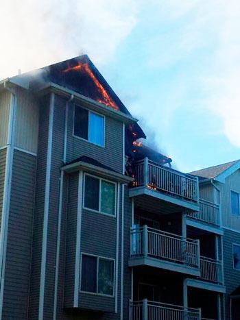 Flames can be seen at the the top of Wasatch Hills apartment building K during a fire on Monday.