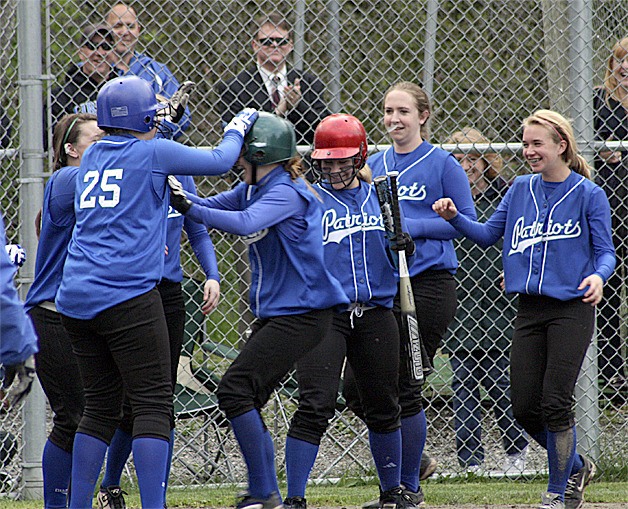 Allie Wood (green helmet) meets her teammates at home plate after a home run May 5.