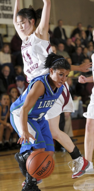 Liberty guard Rayssa Lira (15) is fouled while driving to the basket at Mercer Island on Friday
