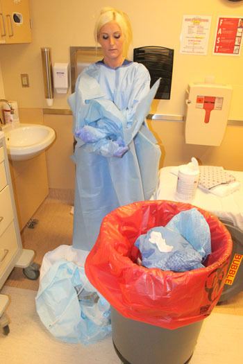 Nurse Roz Currie Parsons carefully removes her protective gear