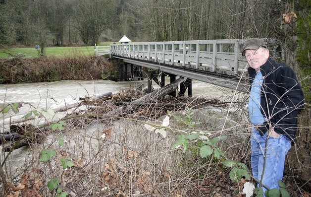 Downtown Renton resident Carl Nordstrom on Tuesday stopped by to take a look at the logs piled up against the  pedestrian footbridge at Renton's Riverview Park on the Maple Valley Highway. The footbridge is closed because of the log jam