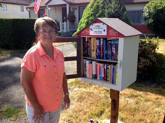 Arlene Willcocks stands by the cubside library she and her husband created in 2012.