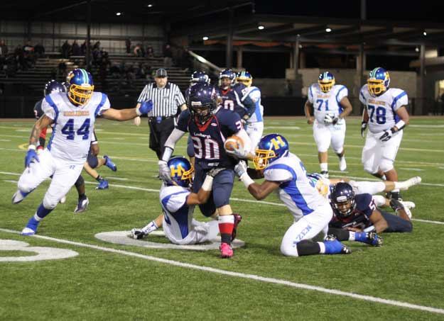 Senior running back Daniel Wiitanen drags a pair of Hazen defenders during Friday's homecoming victory.