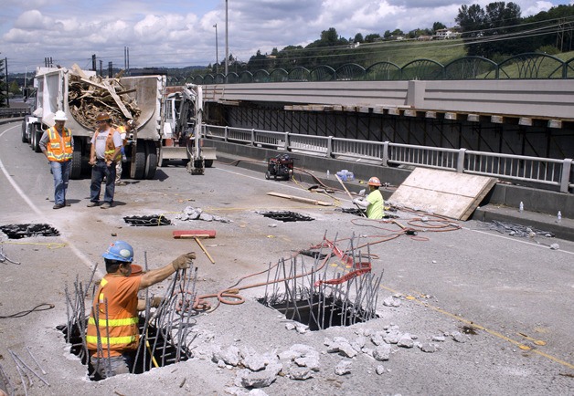 Preliminary work is under way to prepare the now-closed Benson Road bridge for demolition July 10-11. Workers have dug holes into the pavement in order to remove wood that formed part of the structure of the  bridge