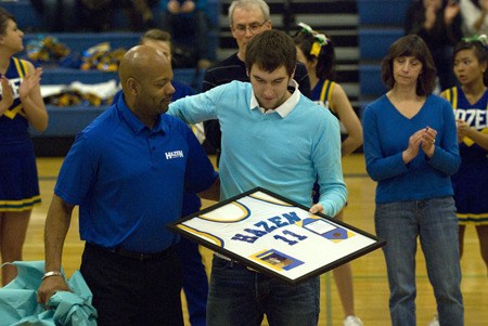 Hazen graduate Caleb Frary and Hazen head coach James Olive stand on the court at halftime of a Jan. 29 game against Lindbergh. The Highlanders retired Frary's jersey.