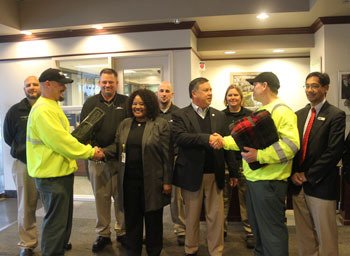 Waste  Management drivers Jason Lange (left) and Russell Ruhle (right) present 100 blankets to Center of Hope Director Dr. Linda Smith and Mayor Denis Law.