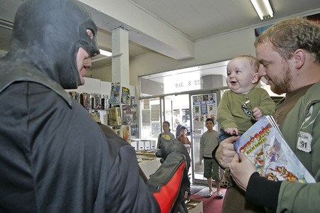The Comic Hut's “Batman” Bill Martin greets Matt Combs of Renton and his six-month-old son Callen during the Renton Spring Festival and Poker Run Saturday in downtown Renton.