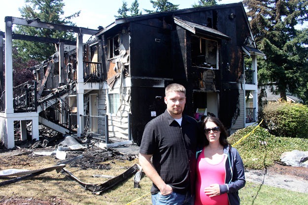 Eric and Whitney Warner stand in front of their burned-out apartment.