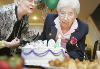 Dora Champoux blows out the candles on her birthday cake as she turns 104