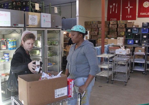 Food bank volunteer Shatay Proctor helps a patron in the Salvation Army Renton Rotary Food Bank. The center only has one of an estimated 500 turkeys needed for this holiday season.