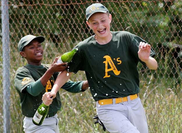 Members of the Athletics celebrate their Cascade Vista Athletic Club little league championship with sparkling cider.