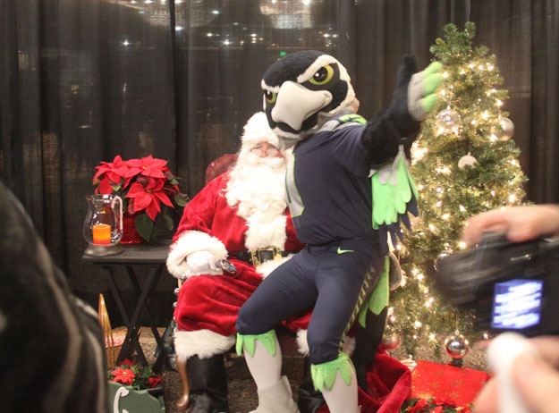 Seattle Seahawks mascot Blitz sits on Santa's lap during the annual Tree Lighting Celebration Saturday at the Piazza.