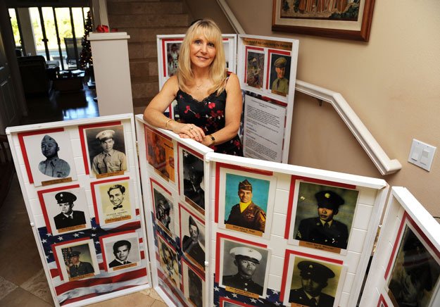 Maui resident Janna Hoehn with her 42 faces of U.S. soldiers killed in Vietnam. She is now looking for images of Renton soldiers killed in the same war.