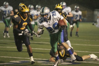 Liberty's Richard Crespo runs away from Bellevue defenders after a reception Friday night. Bellevue won the game 35-7.