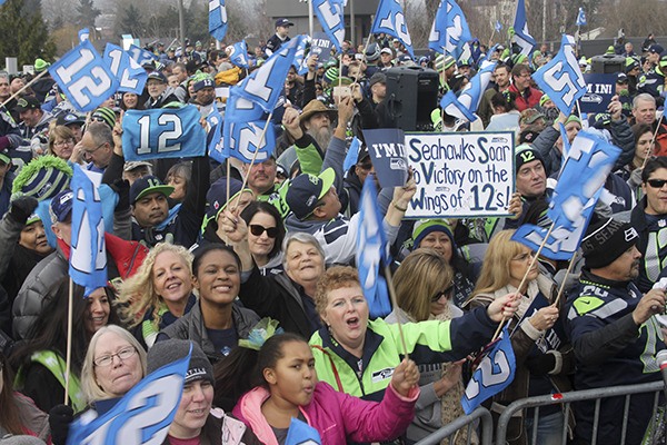 The 12th Man filled the parking lot Friday at noon at Renton City Hall at a rally to whip up support for the Seattle Seahawks in their playoff game Sunday against the Minneapolis Vikings. FIRST PHOTO BELOW: Sandy Cirlincione shows demonstrates who she would celebrate a touchdown that won her a bunch of Seahawks stuff.