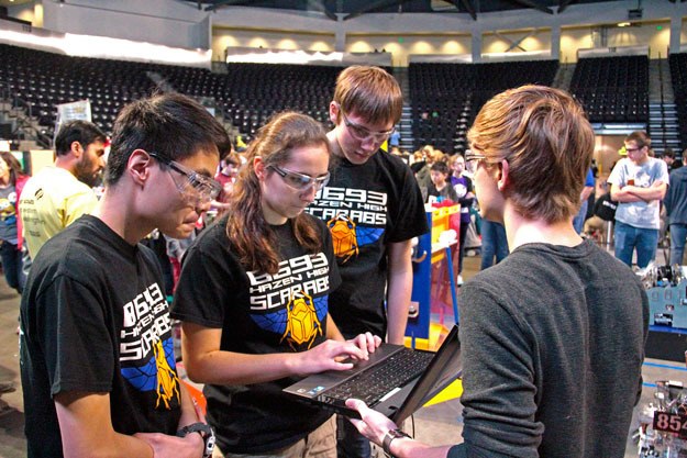 Members of Hazen's FTC robotics team fine tune their machine at the state FIRST Tech Challenge Robotics competition