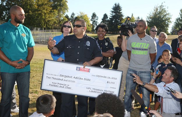 Seattle Sgt. Adrian Diaz accepts a check for $2