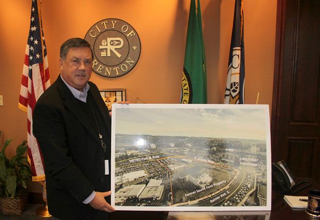 Mayor Denis Law displays an aerial photo of where he would like to see the downtown transit center moved.