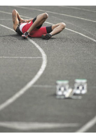 Renton’s Jasen Meyers lies on the track in pain after finishing the 400-meter dash with an injury at the league meet.