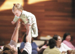 Jenny Schrepfer tosses one of her 10-month-old twins