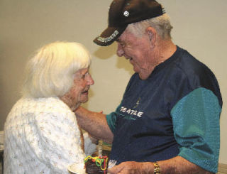 Bert Feskens shares a moment with Verneice Lemis at his going away party Wednesday at Renton Senior Activity Center. Lemis