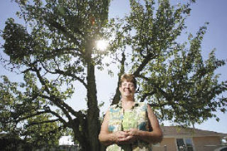 Ann Aarhus stands in front of her 100-plus-year-old Bing cherry tree