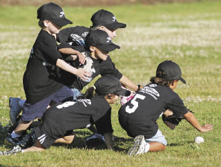 Five members of the Ironbirds play shortstop by committee Thursday in a T-ball game at Kennydale Lions Park.