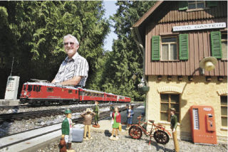 Heinz Eberle of Renton sits alongside his model railroad creation – the fictional town of Berg Gastein. Eberle