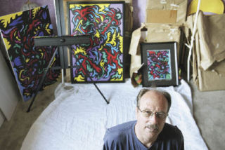David Hatch sits on the floor of his workspace at his Renton home