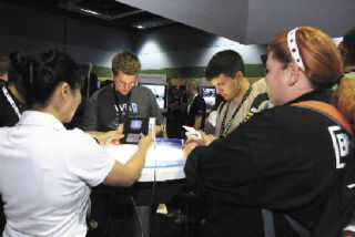 Attendees at the Penny Arcade Expo try out a Nintendo DS title at the Nintendo booth.