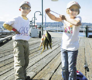 David Gobbo and his sister Carmen show off their catch at Gene Coulon Memorial Beach Park on Lake Washington for the 17th annual Catch A Special Thrill Foundation fishing event for kids on Saturday.